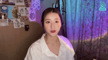 a woman in a white shirt is sitting in front of a wall with pictures of animals on it
