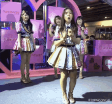 a group of girls are standing in front of a pink sign that says gateway