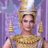 a woman is wearing a gold and blue costume with a crown on her head