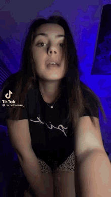 a girl in a black shirt and leopard print shorts is dancing on tiktok