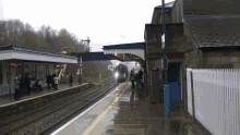 a train station with people waiting and a sign that says ' a ' on it