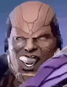 a close up of a man 's face with his tongue out and a helmet on .