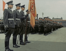 a group of men in military uniforms stand in a line with one man holding a flag that says ii