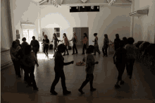 a group of people are dancing in a room