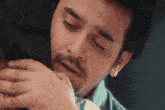a man is hugging a woman with his eyes closed