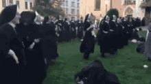 a large group of nuns are dancing in a field