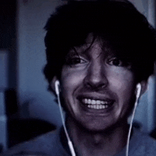 a man wearing headphones is making a funny face while looking at the camera .
