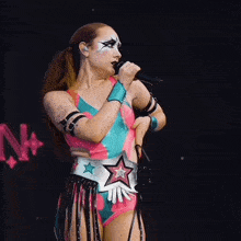 a woman is singing into a microphone in front of a sign that says n on it