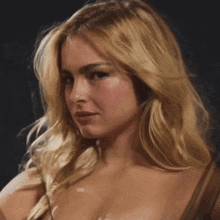a close up of a blonde woman 's face with a dark background