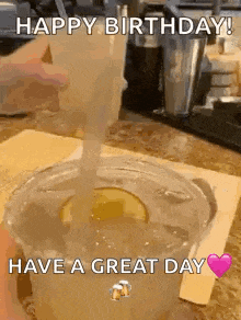 a person is pouring a drink into a cup on a table .