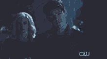a close up of a man in a dark room with a cw logo in the corner