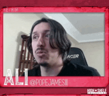 a man with long hair and a beard is sitting in an acer chair