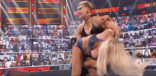 a woman is wrestling another woman in a wrestling ring .