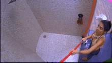 a woman holds a mop with a red handle