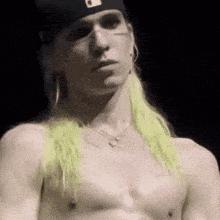 a man without a shirt is wearing a hat and earrings