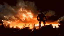 a silhouette of a man standing in front of a city on fire