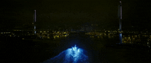 a boat is going under a bridge at night with a blue light coming out of it