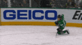 a hockey player is kneeling down in front of a geico sign