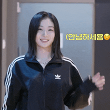 a woman wearing a black adidas jacket smiles