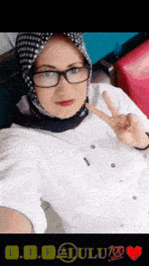a woman wearing glasses and a scarf giving the peace sign