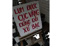 a sign on a wooden easel that says lum duc cuc vang