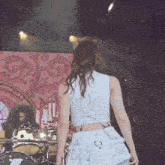 a woman in a blue dress is standing on a stage .