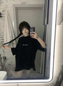 a woman taking a selfie in front of a mirror wearing a black shirt that says i am a canadian