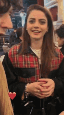 a woman in a plaid jacket is smiling and looking at the camera