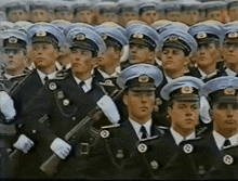 a group of men in military uniforms are standing in a line with their arms crossed