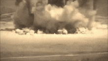 a large cloud of smoke is coming out of a building .