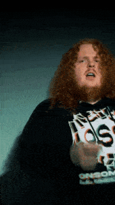 a man with red hair and a beard wears a black hoodie that says onson on it