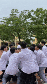 a group of young men are playing tug of war in a park