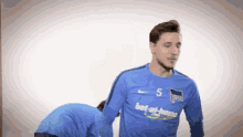 a soccer player wearing a blue jersey with the number 5 on it