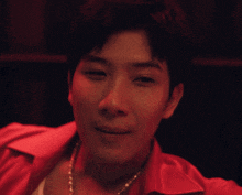 a close up of a man 's face with a red shirt on