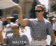 two men wearing sunglasses and striped shirts are standing next to each other in a crowded street .