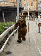 a bear mascot stands in front of a building that says billy gulch on it
