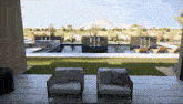 two chairs are sitting on a tiled patio in front of a pool