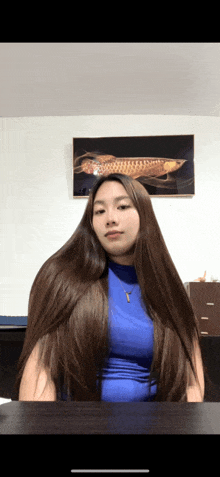 a woman with very long hair wearing a blue top