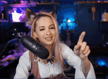 a woman wearing a fox ear headband points at the camera