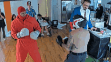 a man in a red jumpsuit is wearing boxing gloves with the word reebok on them