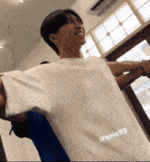 a man with his arms outstretched is wearing a white shirt