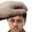a pixelated image of a man with glasses and a hand on his forehead .