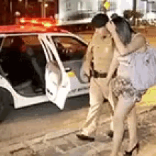 a police officer and a woman are walking down the street .