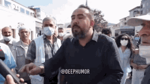 a man wearing a mask stands in front of a crowd and says deephumor on the bottom