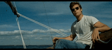 a man wearing sunglasses sits on a boat in the water