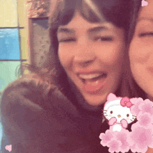two women are posing for a picture with hello kitty
