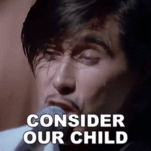 a man singing into a microphone with the words consider our child behind him