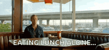 a man is sitting at a table eating lunch alone