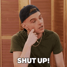 a man wearing a baseball cap and a chain says shut up