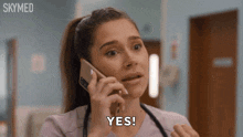a woman talking on a cell phone with the word yes written on her face